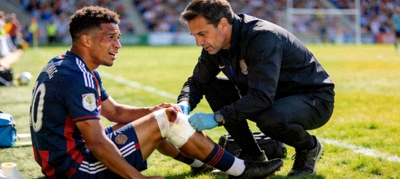 足球运动员在场上接受队医治疗照片